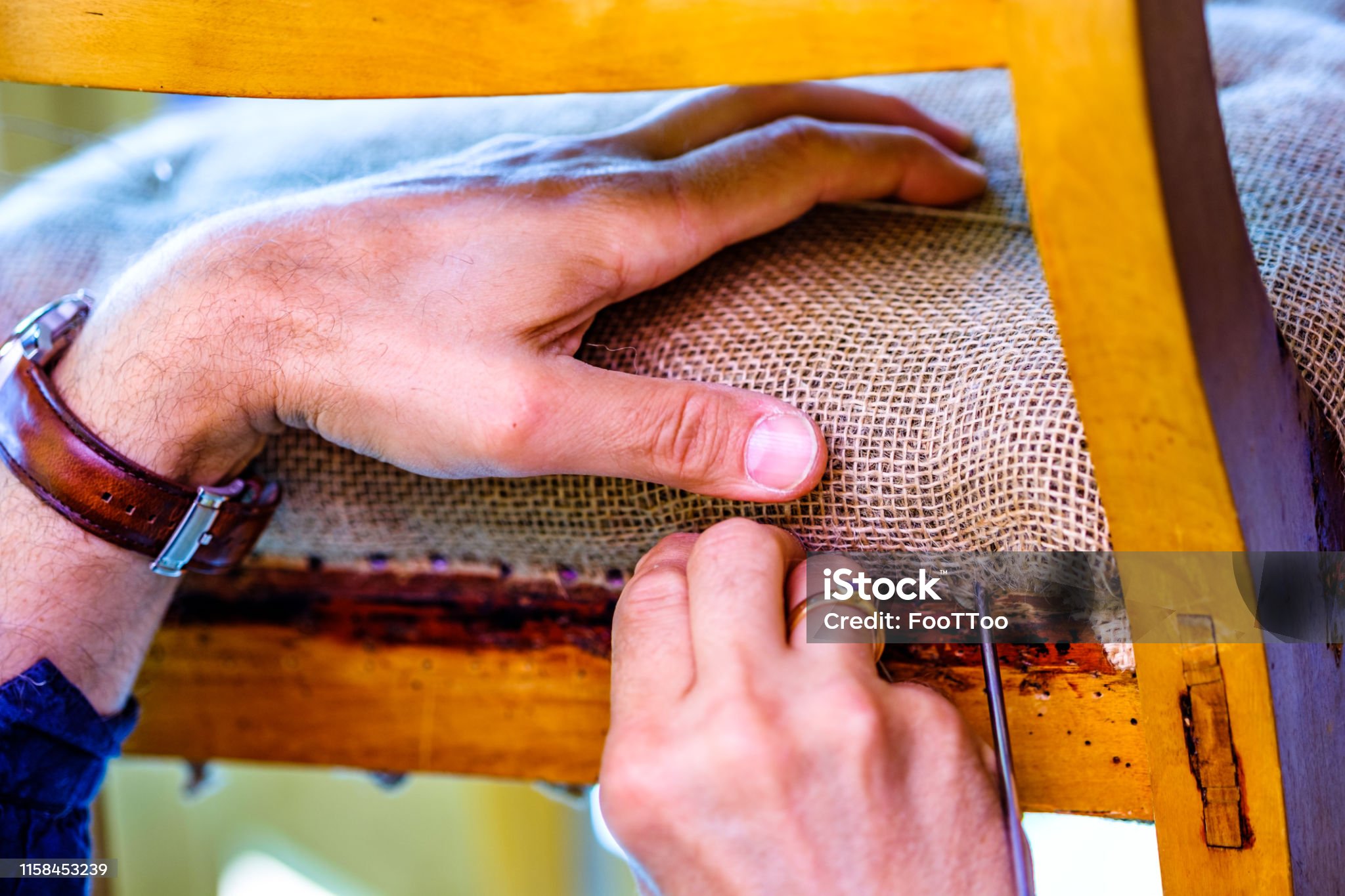 upholsterer is working at an old chair